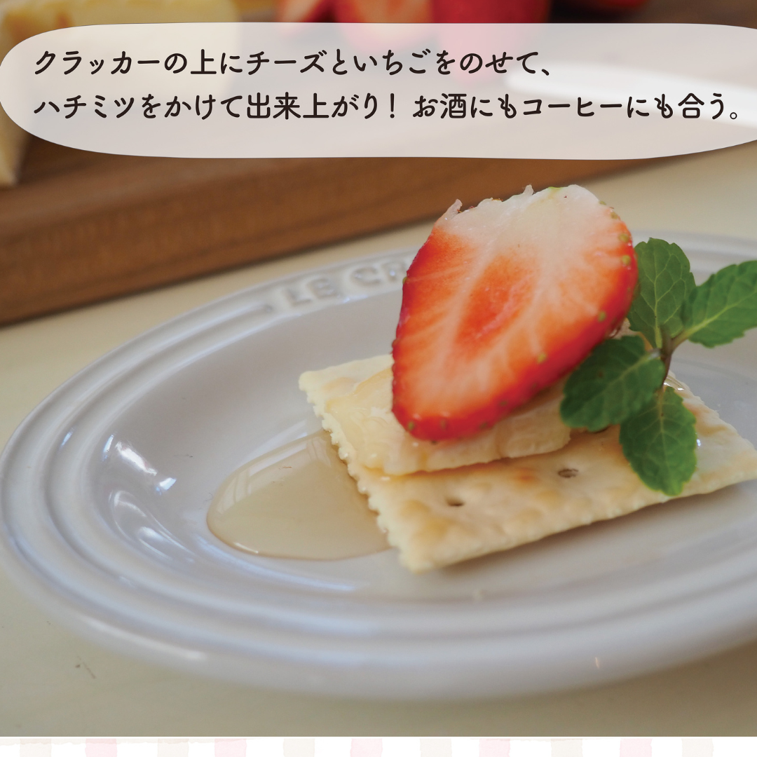 クラッカーにチーズといちごをのせ、ハチミツをかけたいちごのカナッペ